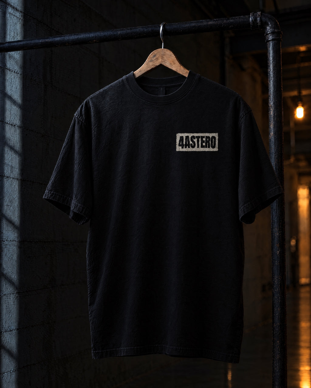 Front of the black 4ASTERO heavyweight tee with the small chest logo, on a hanger