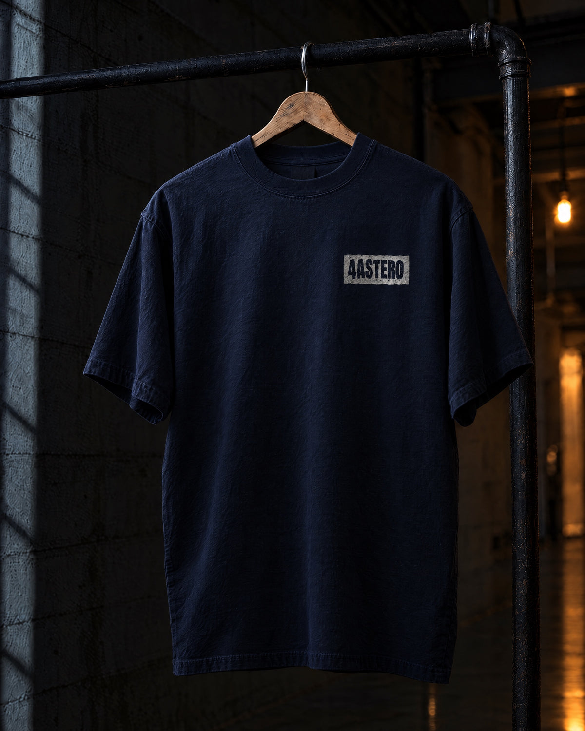 Front of the navy 4ASTERO heavyweight tee with the small chest logo, on a hanger