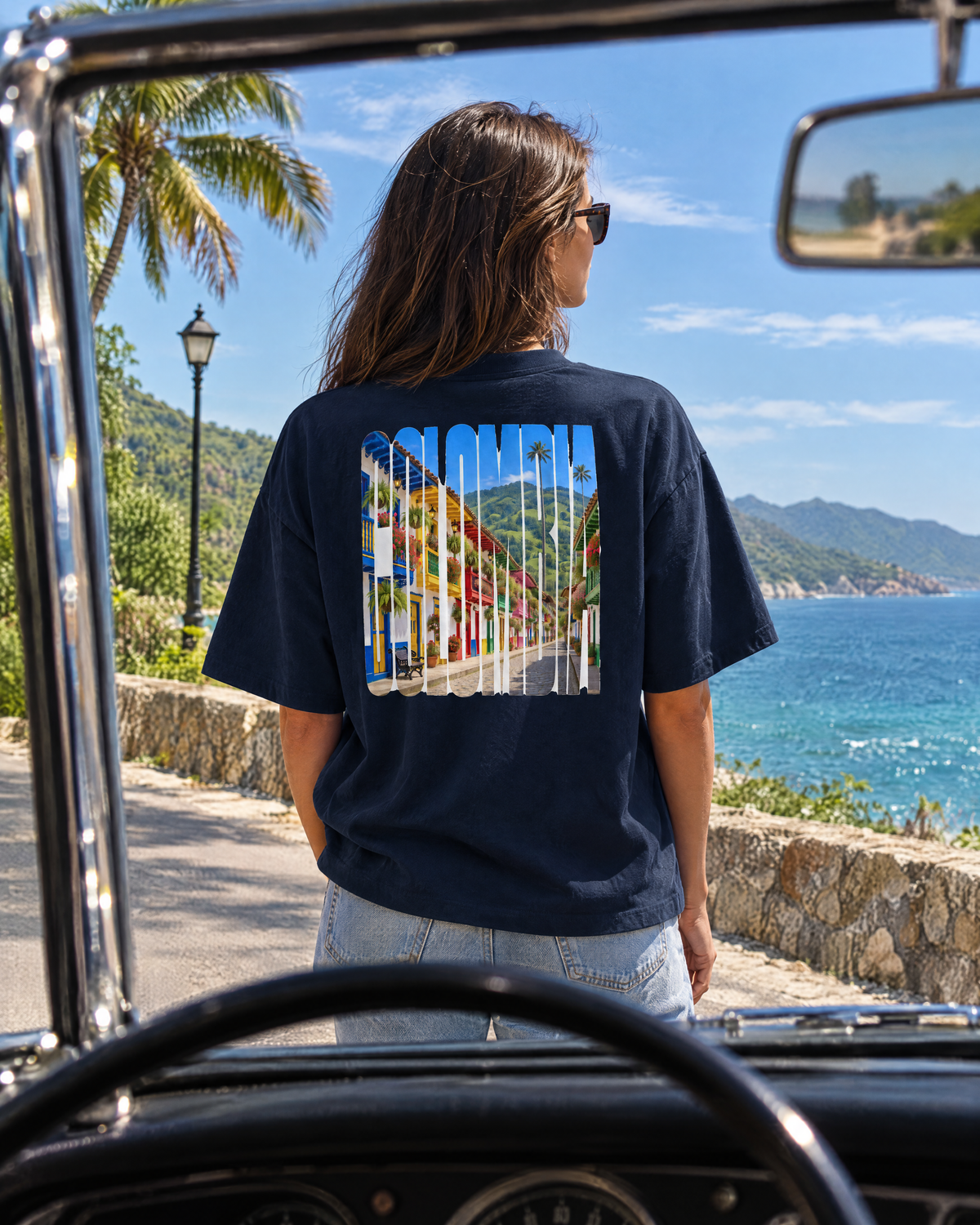 Woman in a French navy Salento tee by a convertible on a Caribbean coast road