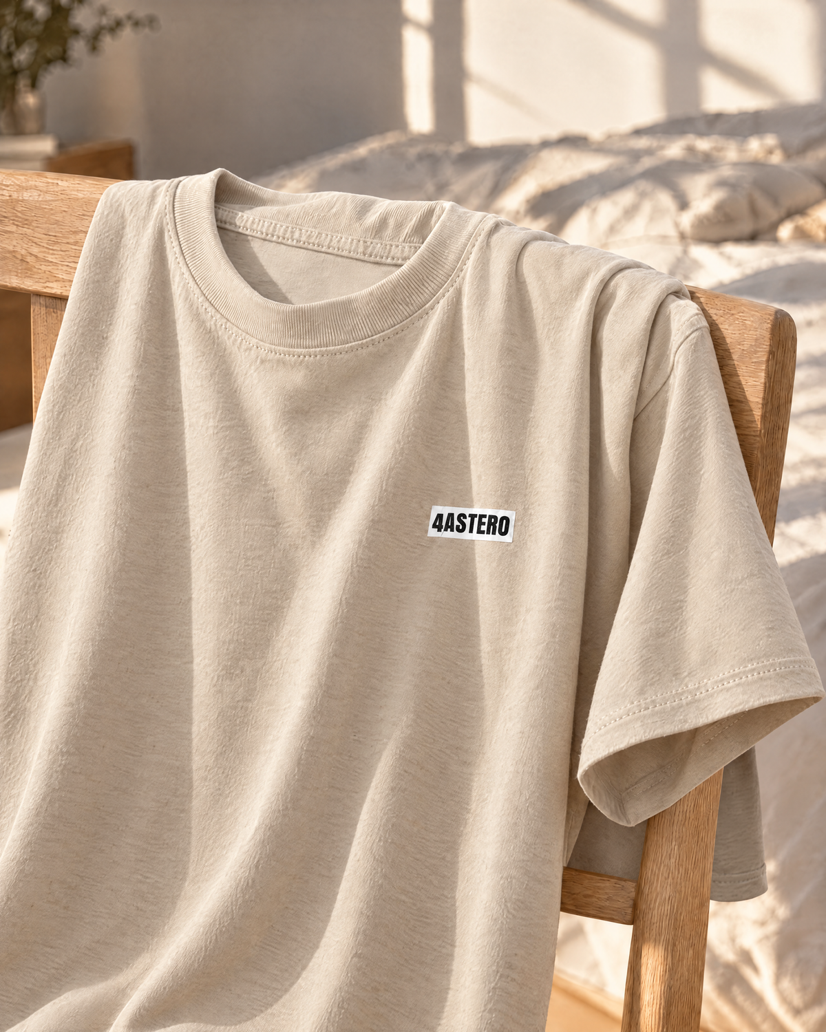 4ASTERO tee in cream, front, draped over an oak chair